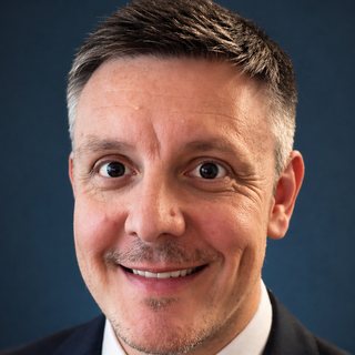 Steve Darlow, smiling, in a dark suit